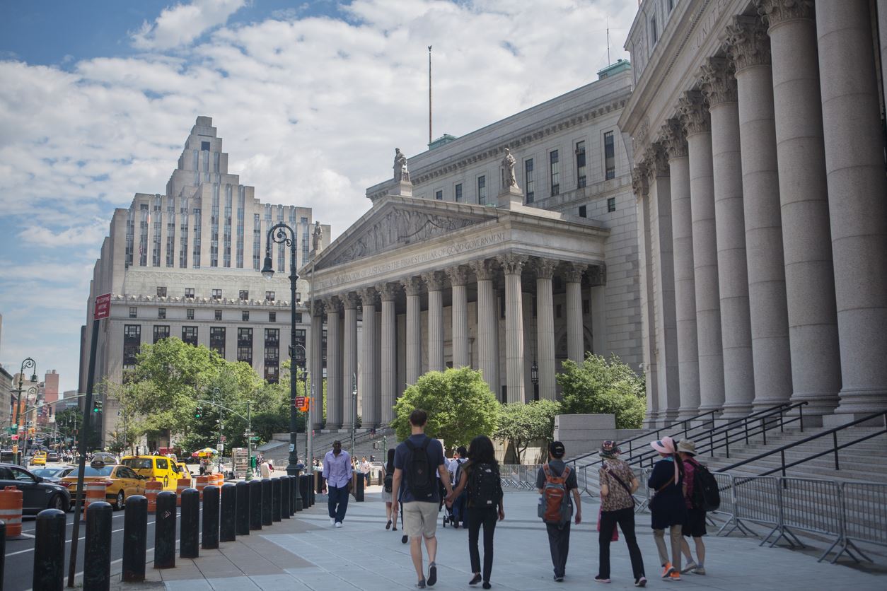people walking in front of new york court building